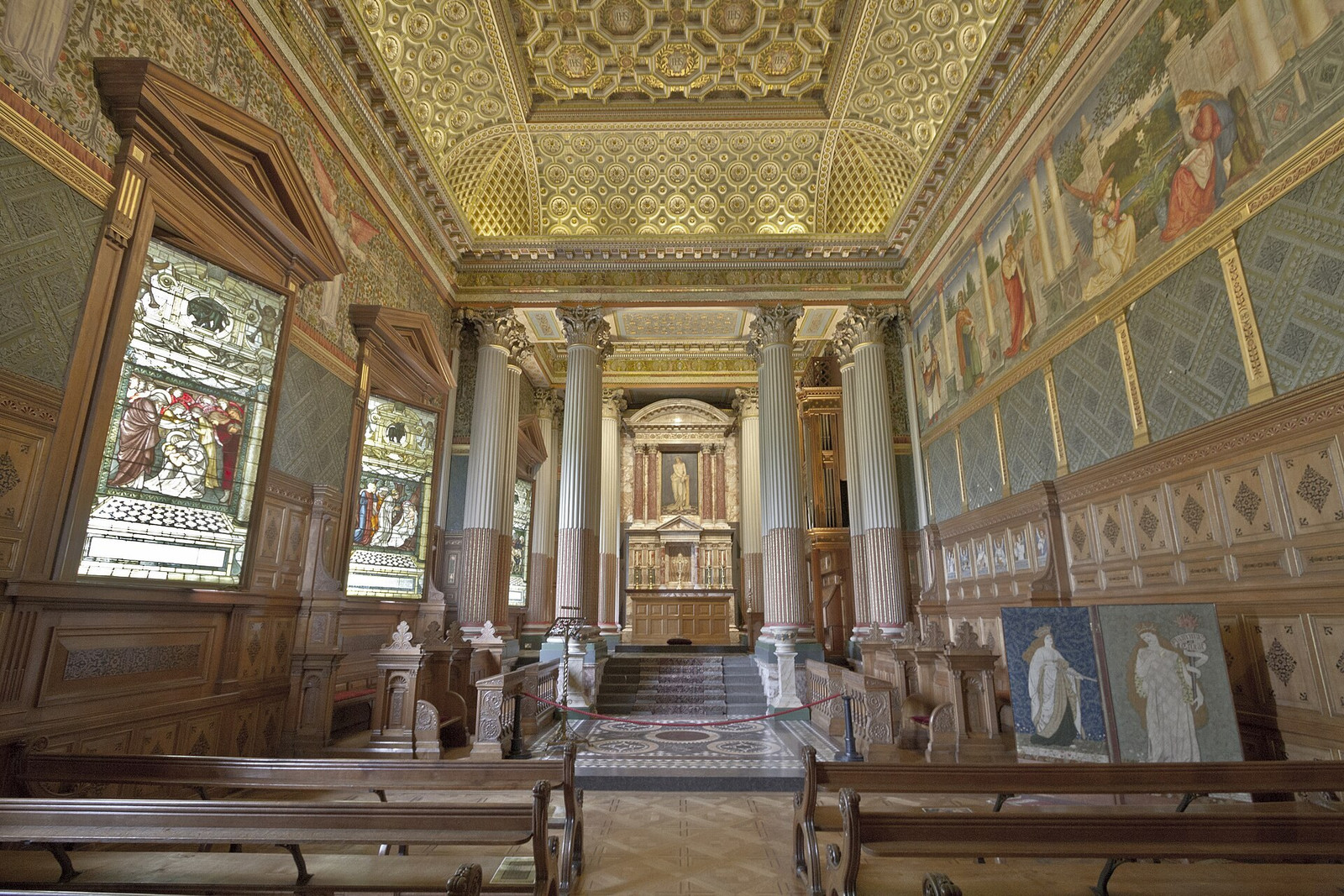 Castle Howard chapel with patterned ceiling, stained glass, murals, and timber stalls