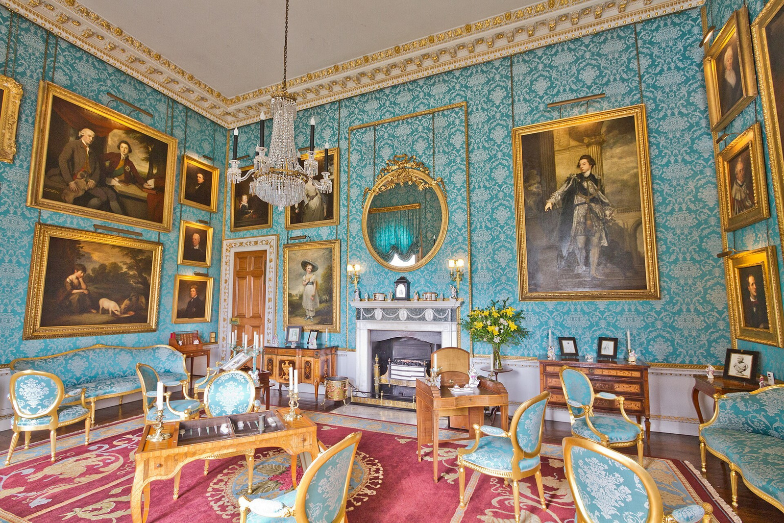 Turquoise Drawing Room with blue-green walls, portraits, fireplace, and gilt seating