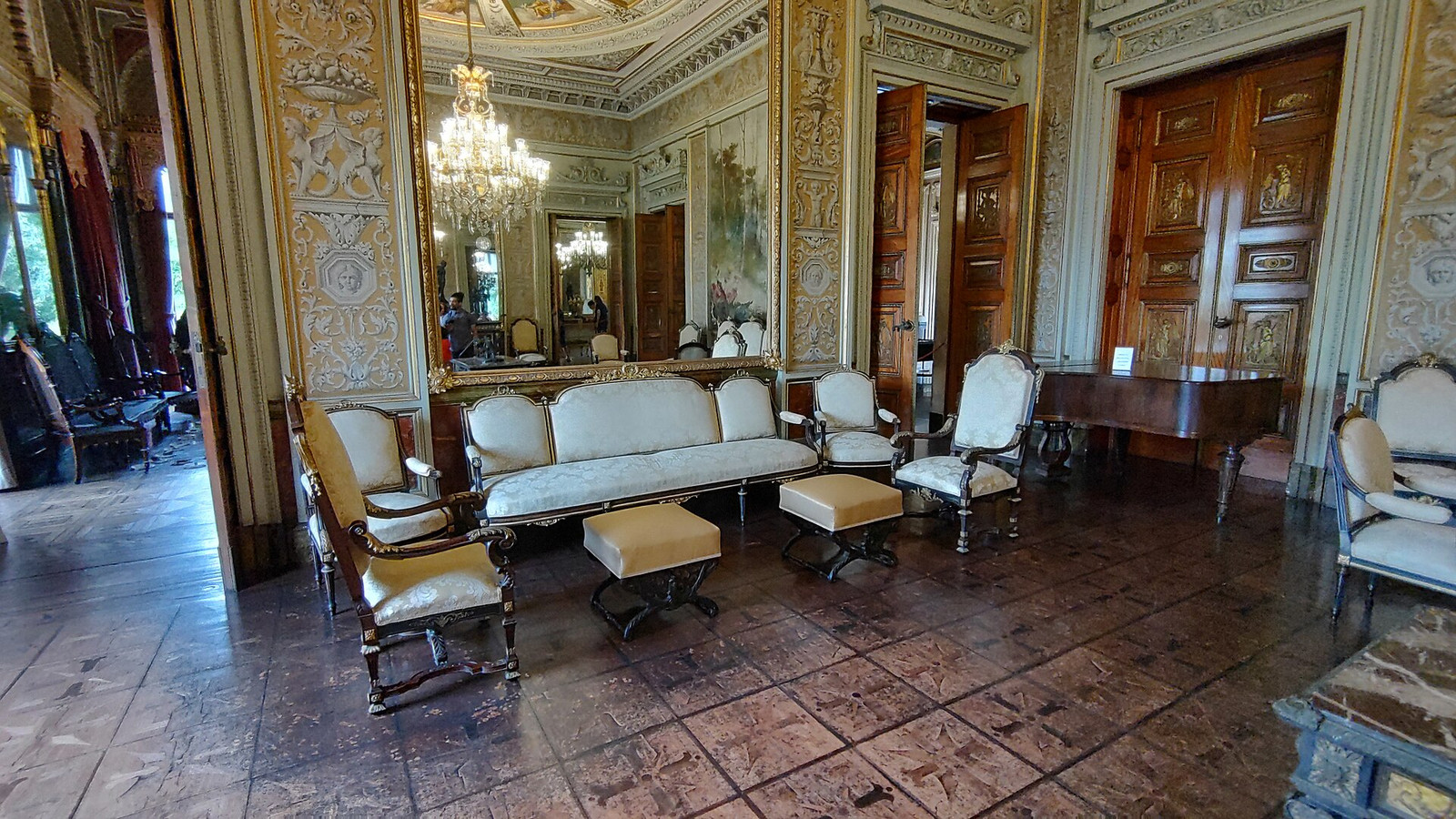 Formal salon at Palácio do Catete with mirrored walls, chandelier, piano, and upholstered seating