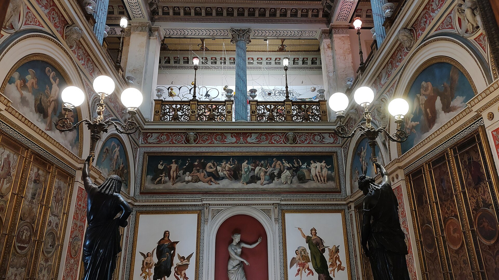 Two-story gallery inside Palácio do Catete with painted panels, columns, and carved balustrades
