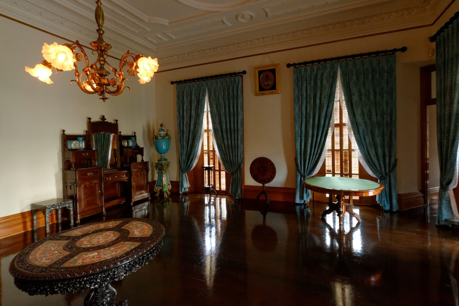 King Kalākaua’s bedroom with blue textiles, writing furniture, and tall windows