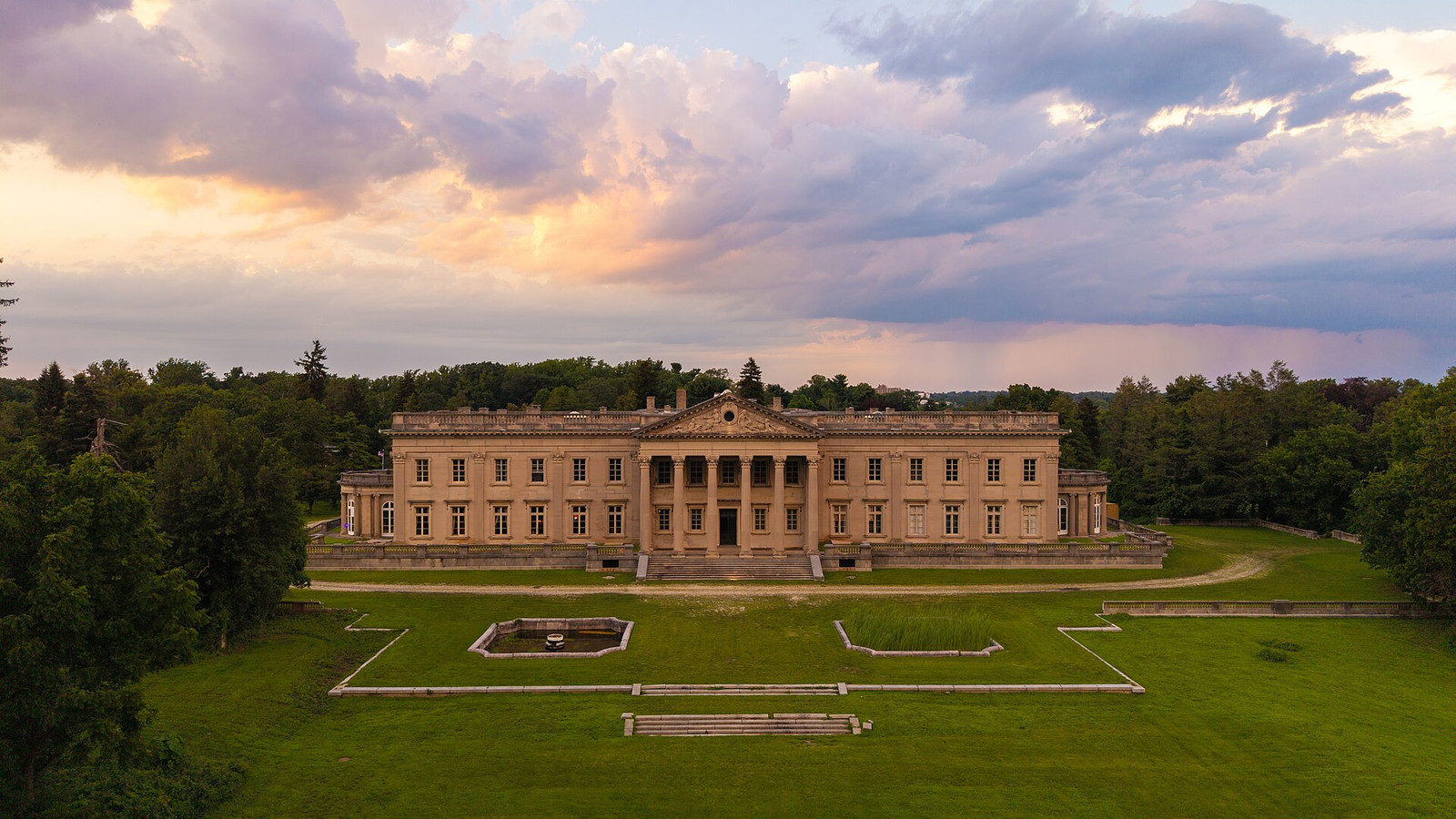 Aerial view of Lynnewood Hall and its wooded 34-acre estate at sunset