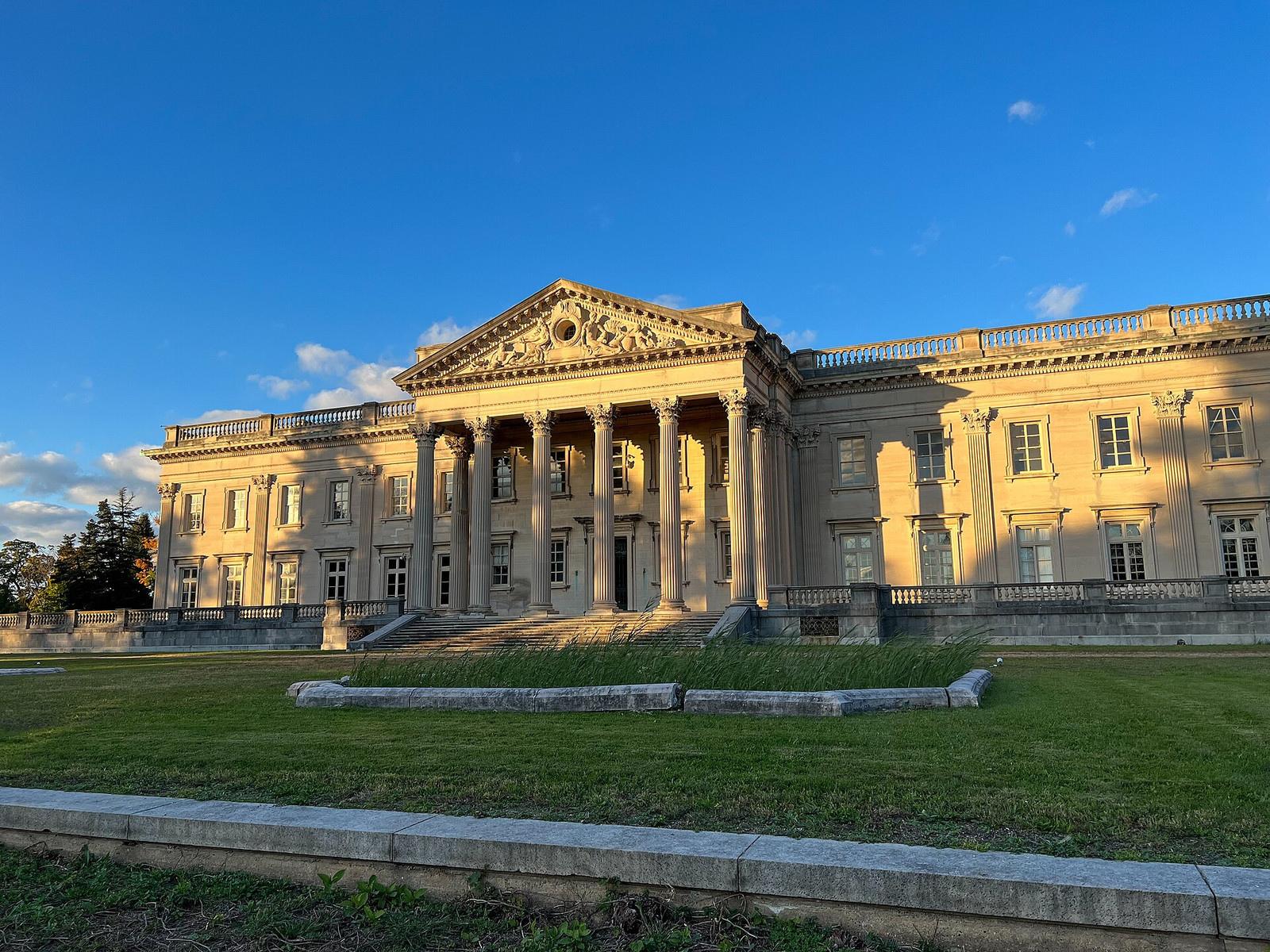 The limestone façade of Lynnewood Hall illuminated at dusk