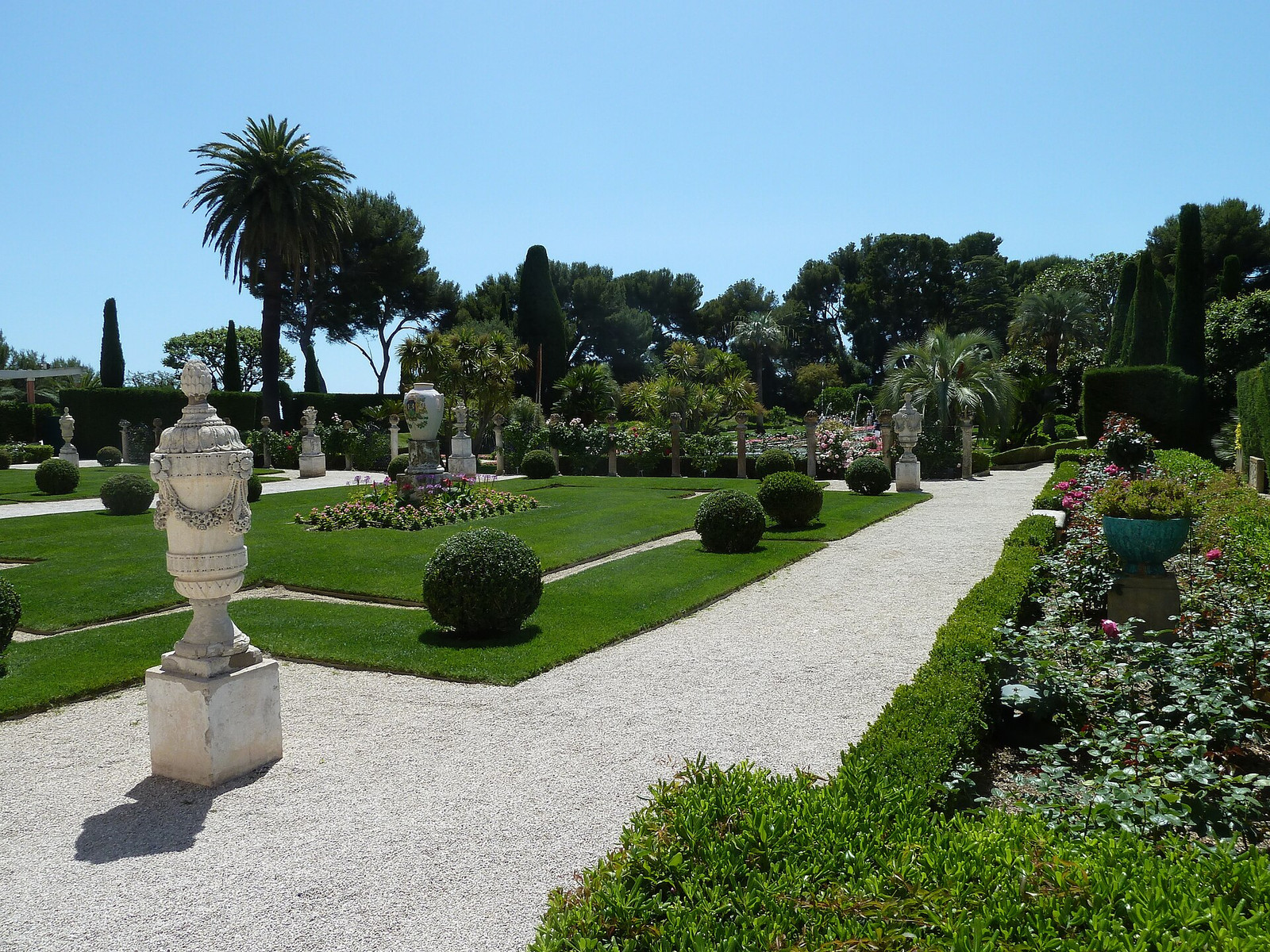 The long formal French garden at Villa Ephrussi de Rothschild with fountains leading toward the rose-colored villa