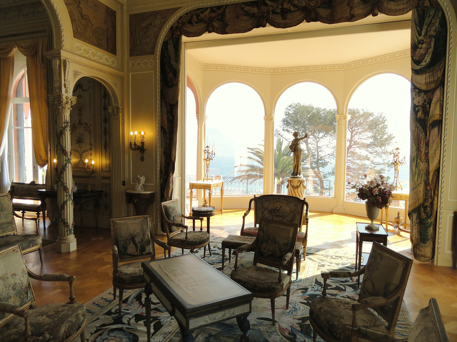 The Grand Salon at Villa Ephrussi with gilded furnishings and tall arches opening toward the Mediterranean