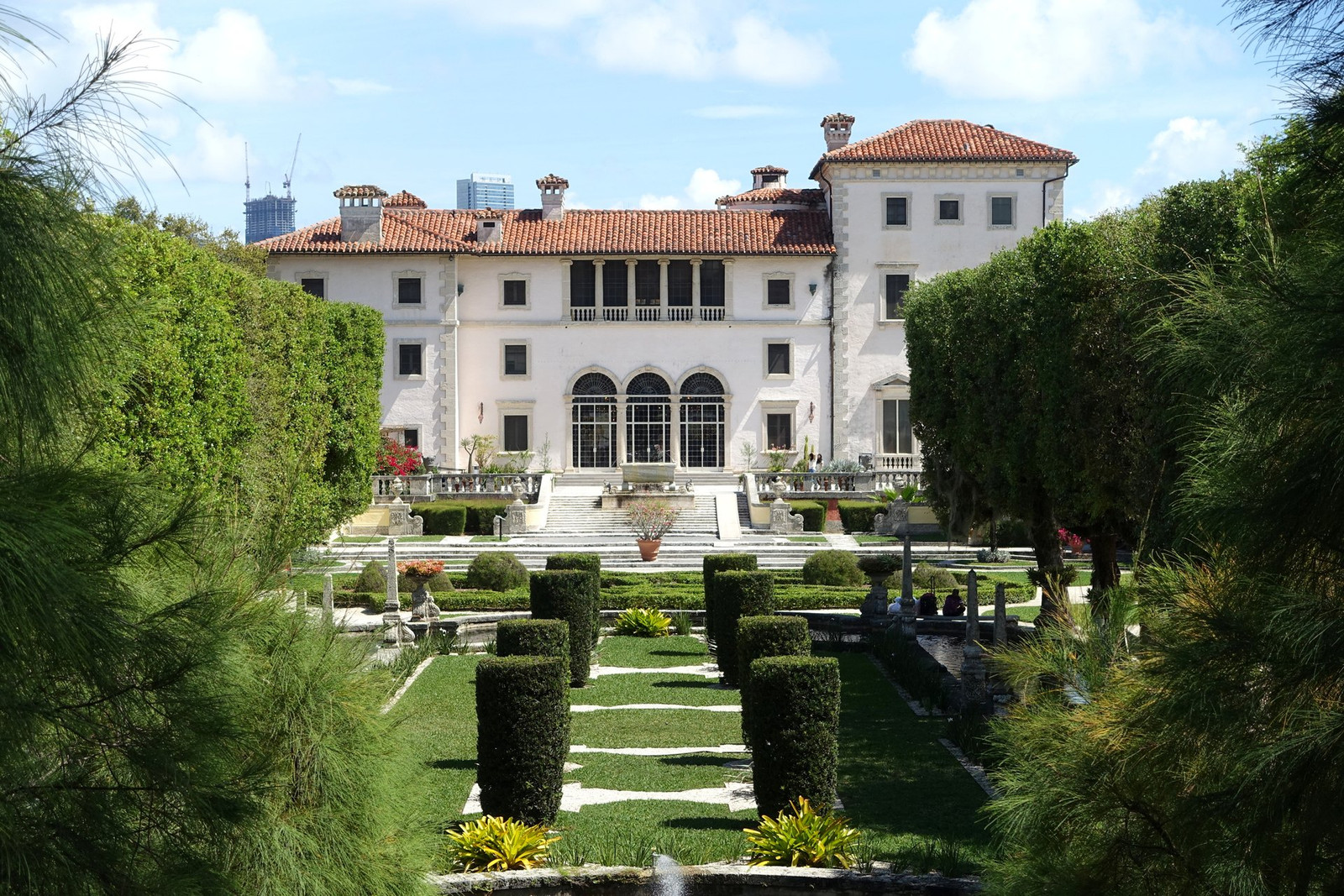 Vizcaya’s pale garden elevation beyond clipped hedges and palms