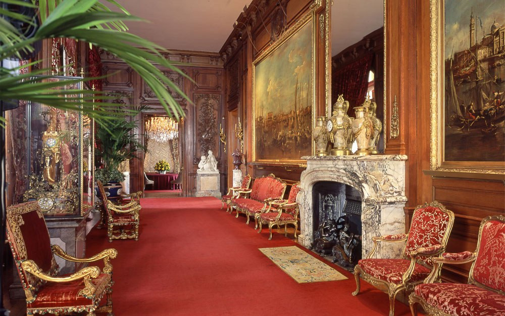 East Gallery at Waddesdon Manor with paintings, sculpture, chandeliers, and gilded furniture