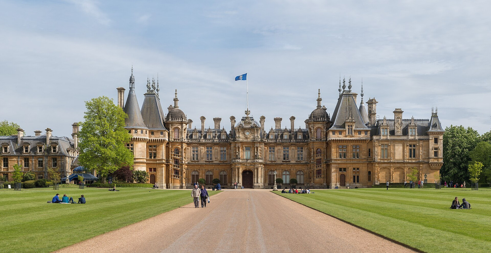 North façade of Waddesdon Manor with towers, steep roofs, and carved golden stone